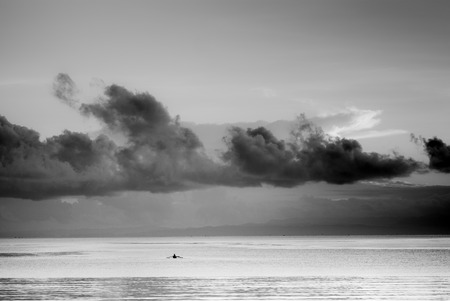 Fishing boat at the see under the dark clouds in Black and Whiteの写真素材