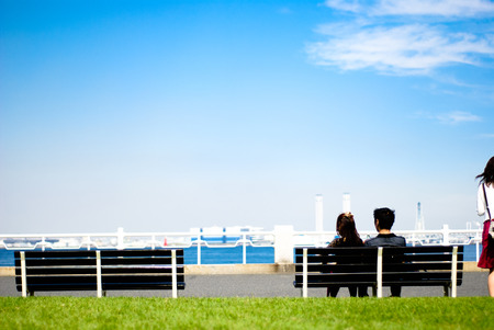 Lovers enjoting the day at the seaside park benchの写真素材