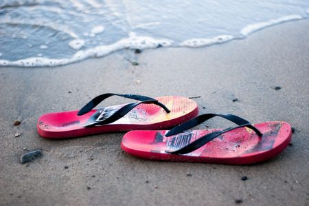 A pair of red slippers at the sand of Lobo Beach, Batangas, Philippinesの写真素材
