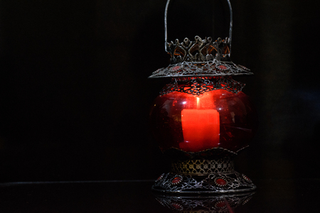 Red candle holder in black background.の写真素材
