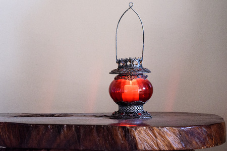 Red candle holder at the wooden table.の写真素材