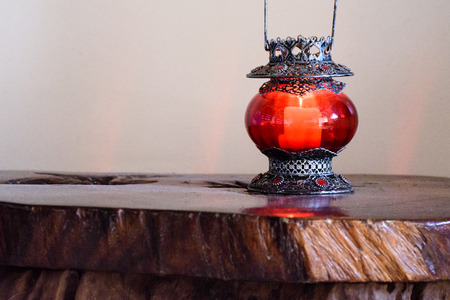 Red candle holder at the wooden table.の写真素材
