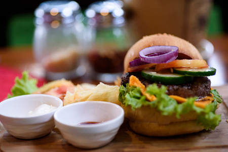 Chesse burger with vegetables and chips.の写真素材