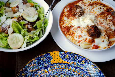 Lasagna and vegetable salad on the table.の写真素材
