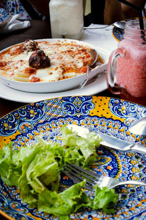 Lasagna and vegetable salad on the table.の写真素材