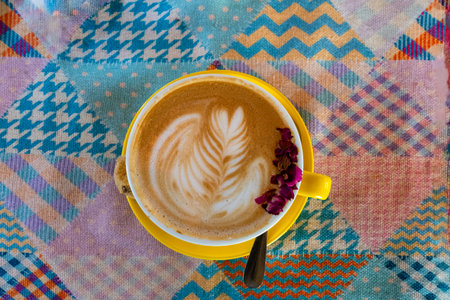 Top view of cappuccino in yellow cup and saucer with latte art.の写真素材