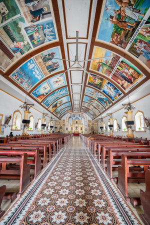 Interior of Bangar Church in Ilocos Sur, Philippines. A large church with a high ceiling. Painting in the ceiling includes references to the power of the Holy Spirit, the body of the Virgin Mary, the finding of Jesus, and the temple.の写真素材