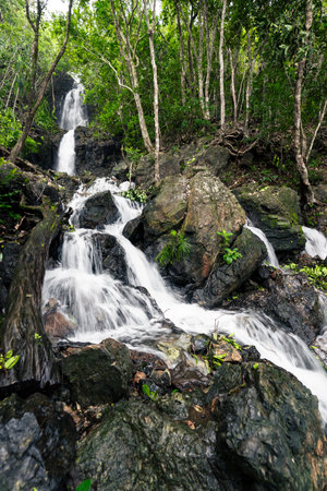 A stunning Diguisit Falls in Aurora cascading down moss-covered rocks in a lush, green forest. The surrounding vegetation and rugged terrain enhance the natural beauty of this peaceful and refreshing wilderness scene.の写真素材