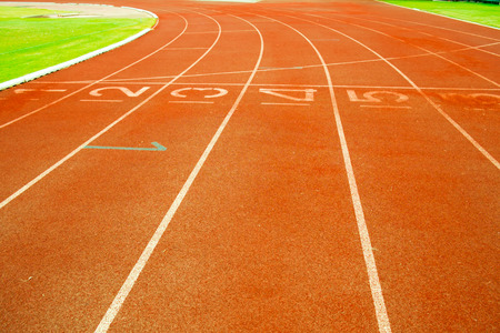 Red treadmill at the stadium with white lines