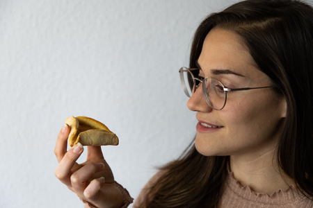 Beautiful and happy women portrait eating hamantash Purim apricot cookieの写真素材