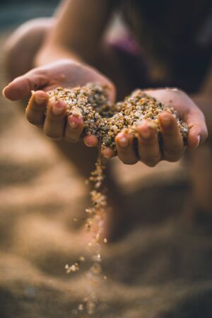 Dropping sand from both handsの写真素材