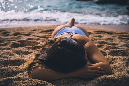 Girl laying face down on the beach