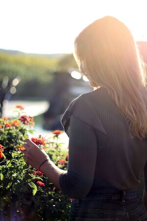 Women back shot holding flower with sunset light