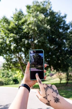 Taking picture of a tree with a smartphoneの写真素材