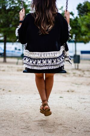 Girl on a swing back shot no headの写真素材