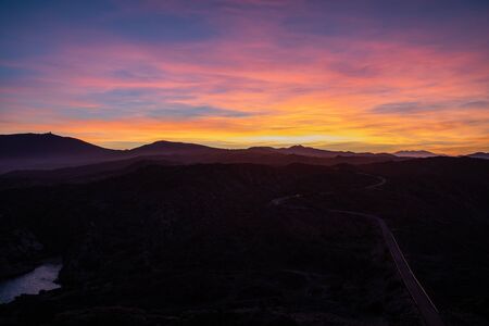 Sunset sky view with mountains with pink, yellow and purple colors in Cap de Creus, Cataloniaの写真素材