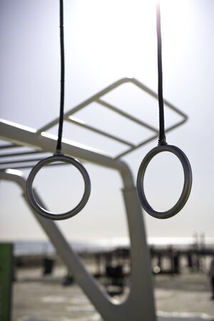 Gymnastics rings at outdoor training spot or street workout with blue clear sky on background in Barcelona beach (SPAIN)の写真素材