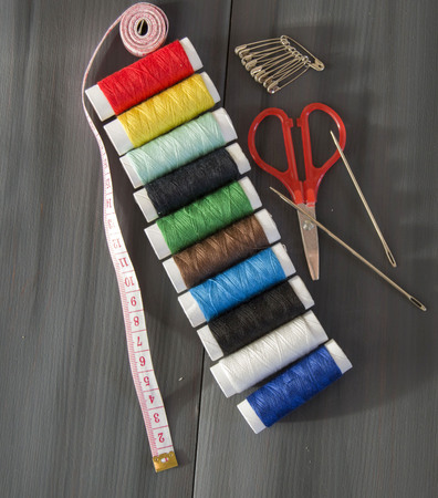 colored sewing spools and needles to sew