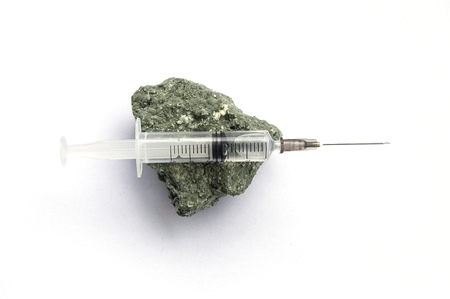 syringe on white ground and moldy cheeseの写真素材