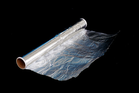 roll of aluminum foil isolated on black background