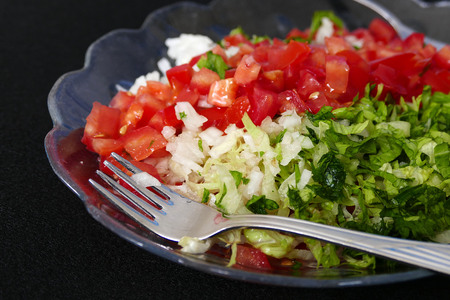 vegetable salad in plate on black background