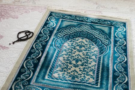 Islamic symbols, prayer rugs on a carpet in a house,の写真素材
