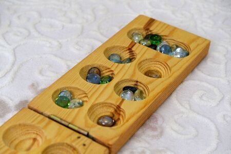 old intelligence games, wooden mancala game, a person playing mancala,の写真素材