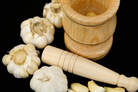 Garlic and wood garlic crusher,garlic grains on wooden background, close up,の写真素材