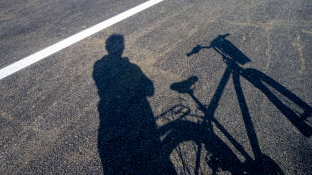 bike and human shadow, bike and on asphalt road,の写真素材