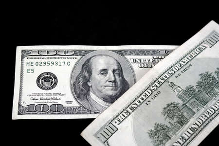 100 US dollars on a black background, the world market and 100 usd gaining value,