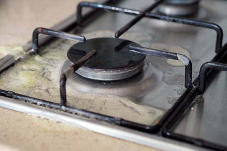 milk overflowed on the cooking stove and it got dirty,の写真素材