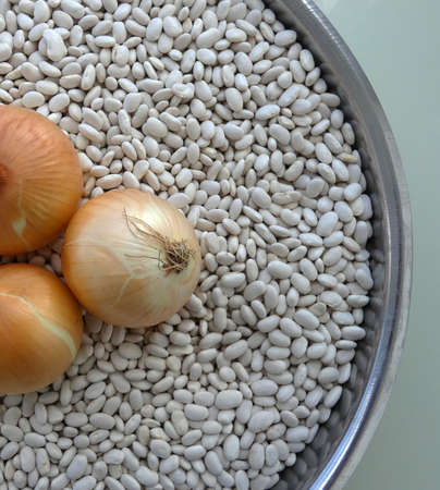 white beans and three onions in a bowl,の写真素材