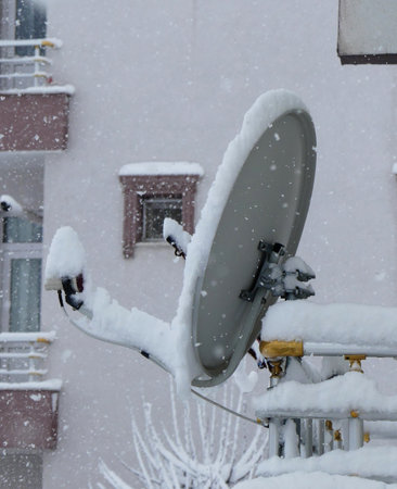 satellite antenna under the snow on the roof, snow accumulated on the roof in winter, snowstorm,の写真素材