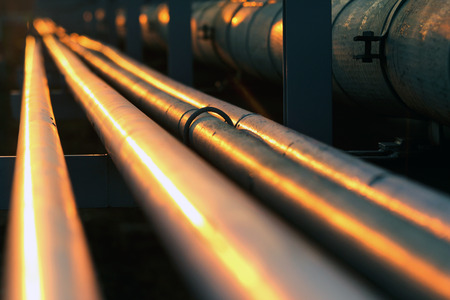long pipe line in oil refinery during sunset