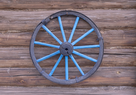 wheels from the cart on the wall of the stablesの写真素材