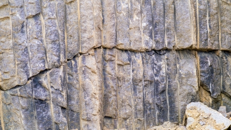 Broken granite in a stone quarrywith the drill markings used to fill in explosives