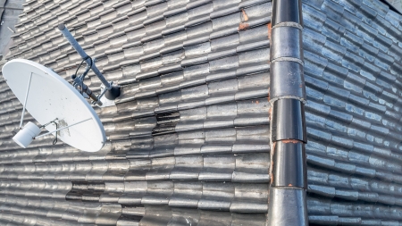 Tile roof with satellite receiver seen from aboveの写真素材