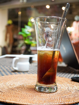 Glass of iced tea with ice on table in coffee shop, stock photoの写真素材
