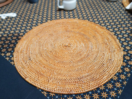 Round rattan tablecloth on the table in a cafe. Selective focus.の写真素材