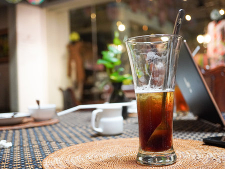 Glass of cola with ice on table in coffee shop, stock photoの写真素材