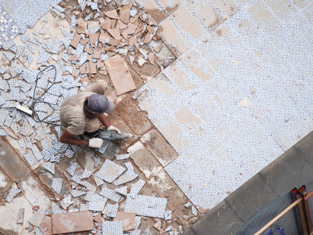 Bricklayer laying ceramic tiles on floor in the construction site.の写真素材