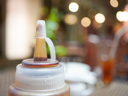 Bottle with liquid on a table in a cafe. Selective focus.の写真素材