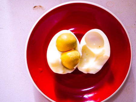 Boiled egg on a red plate, closeup of photo.の写真素材