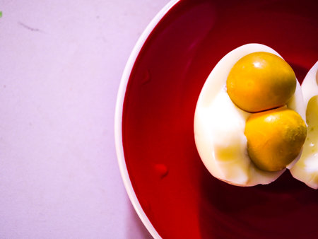 Boiled egg in red plate on wooden table. Top view.の写真素材