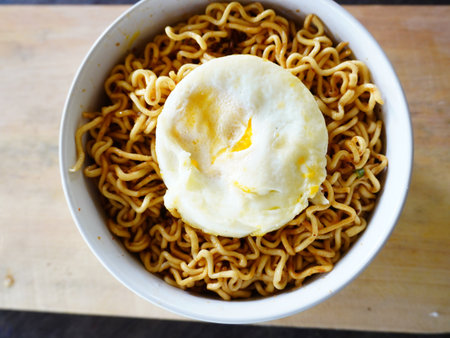 Instant noodle with egg yolk in white bowl.の写真素材