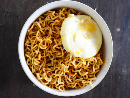 Instant noodles with ice cream in white bowl on wooden table background.の写真素材