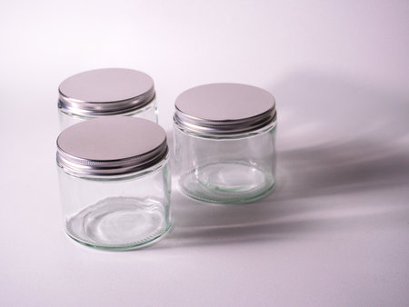 Empty glass jars on a white background. Isolated with shadow.の写真素材