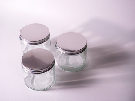 Empty glass jars on a white background. Shallow depth of field.の写真素材