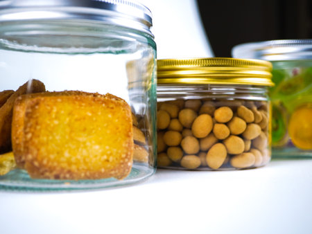 Glass jar with olives and crackers on a white background.の写真素材