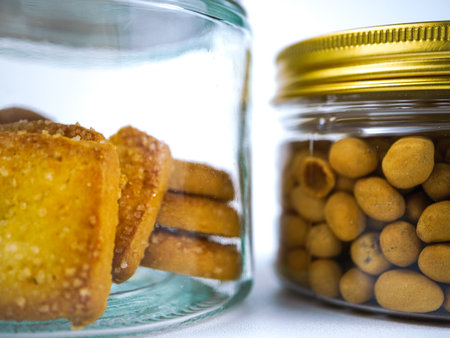Close up of a glass jar filled with crackers on a white backgroundの写真素材